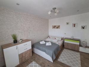 a small bedroom with a bed and a dresser at Къща за гости ИЛТА in Novo Delchevo