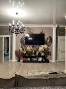 a living room with a couch and a chandelier at Aura in Dzerzhinskoye