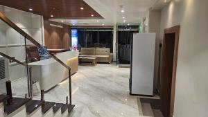 a living room with a staircase and a white refrigerator at Hotel bharti international in Raipur