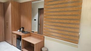 a room with a wooden wall with a desk and a mirror at Hotel bharti international in Raipur