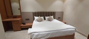 a bed with white sheets and pillows in a room at Hotel bharti international in Raipur