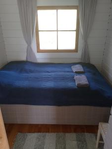 a large bed in a room with a window at Lomamökki Rantaniemi in Töfsala