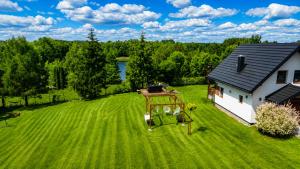 an aerial view of a yard with a house at Domek z kominkiem nad jeziorem z jacuzzi ogrodowym in Sumowo