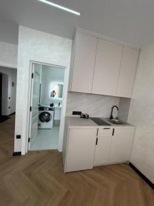 a kitchen with white cabinets and a sink at Поляна Апарт in Polyana +9 photos