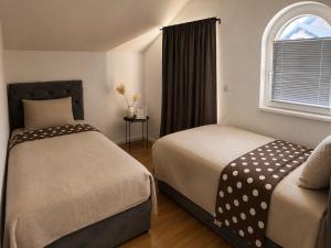 a hotel room with two beds and a window at Villa Zlatan Poolside in Bosanska Gradiška +13 photos