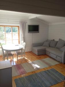 a living room with a couch and a table at Lomamökki Rantaniemi in Töfsala