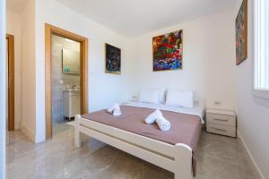 a bedroom with a bed with two towels on it at Barcelona Hacienda in Gostovići +16 photos