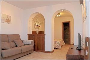sala de estar con sofá y 2 arcos en Estudio en el centro de Conil, en Conil de la Frontera