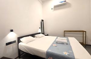 a bedroom with a bed with white sheets and flowers on it at Surf and stay A- Bay in Arugam Bay