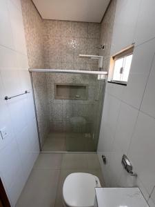 a bathroom with a toilet and a glass shower at CASA para TEMPORADA in Barra do Garças +9 photos