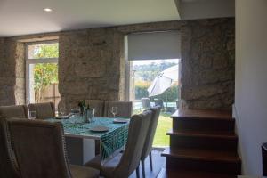 a dining room with a table and chairs and a window at Casa da Pontelha by Gerês Casas in Terras de Bouro