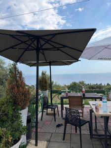 eine Terrasse mit Tisch, Stühlen und Sonnenschirm in der Unterkunft Azure Haven in Dhërmi