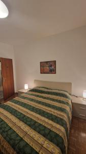 a bedroom with a large bed with a green blanket at Casa Pino Malè in Malè