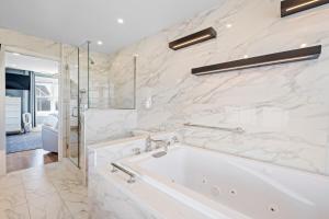 a white bathroom with a tub and a shower at Luxury York Oceanfront Nubble Views in York +54 photos