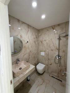 ein Badezimmer mit Toilette, Waschbecken und Dusche in der Unterkunft Azure Haven in Dhërmi