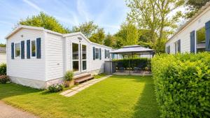 a white house with a garden and a gazebo at Le Cottage D'Oléron, Mer et Animation Camping in Saint-Pierre-dʼOléron