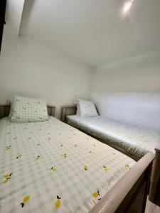 two beds in a small room with flowers on the mattress at Beau T3 à 15 min de Lyon in Pierre-Bénite