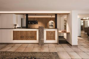 a lobby with a counter with welcome signs on it at Hotel Steger-Dellai in Alpe di Siusi +35 photos