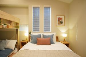 a bedroom with a bed with blue and white pillows at LinksHotel 西荻窪 in Ogikubo
