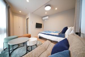 a bedroom with a bed and a couch and a table at LinksHotel 西荻窪 in Ogikubo