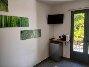a room with a door and a television on the wall at Chez Sab et chaton in Saint-Leu