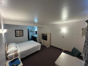 a hotel room with a bed and a desk at Centennial Motel in Sauble Beach