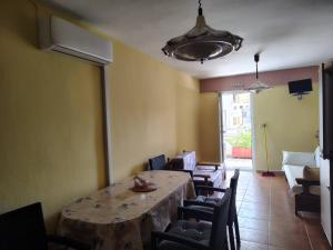 a dining room with a table and chairs and a light at Thomas Vrasna Close To The Sea in Nea Vrasna