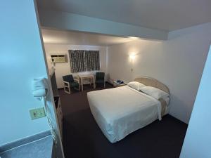 a hotel room with a bed and a table at Centennial Motel in Sauble Beach