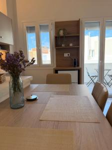 a dining room table with a vase of flowers on it at Afroditi Syros in Ermoupoli