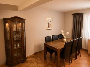a dining room with a wooden table and black chairs at Villa Zlatan Poolside in Bosanska Gradiška