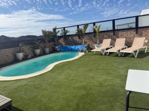 a yard with chairs and a swimming pool at Corralejo Branded Residensed in Corralejo