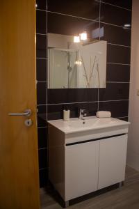 a bathroom with a white sink and a mirror at Casa da Carvalha Mona in Rio Caldo +35 photos
