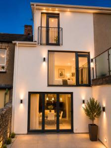 a white house with black windows and a patio at 4 Bedroom Cardiff Bay View House in Cardiff
