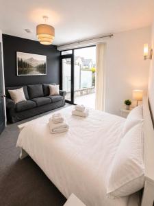 a bedroom with a large white bed and a couch at 4 Bedroom Cardiff Bay View House in Cardiff