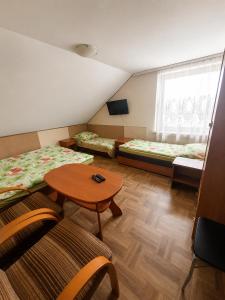 a small room with two beds and a table at Agroturystyka Hogata in Wąchock
