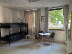 a room with a bunk bed and a table and chairs at Zentrales Boardinghouse MG Rheydt in Mönchengladbach +15 photos