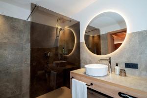 a bathroom with a sink and a shower with a mirror at Hotel Ciamp in Santa Cristina Gherdëina +33 photos