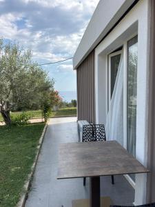 ein Holztisch und zwei Stühle auf einer Terrasse in der Unterkunft Azure Haven in Dhërmi