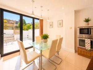a dining room with a glass table and chairs at 4 Bedroom Cardiff Bay View House in Cardiff