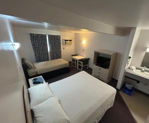 a hotel room with a bed and a television at Centennial Motel in Sauble Beach
