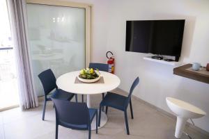 a dining room with a white table and blue chairs at Dai Massari in Villaggio Azzurro