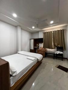 a bedroom with a bed and a chair in it at Hotel moon palace in Maheshwar