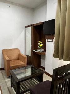 a living room with a chair and a coffee table at Hotel moon palace in Maheshwar