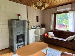 a living room with a couch and a fireplace at Kodikas Mökki in Ähtäri