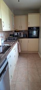 a kitchen with white cabinets and a black microwave at Sailor's Rest in Anstruther