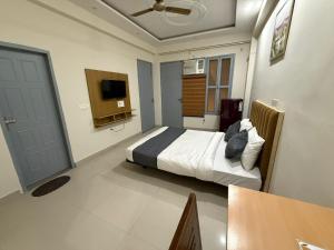 a bedroom with a bed and a flat screen tv at Cloud Bay Hotels - Sector 69 in Gurgaon