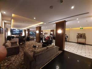 a lobby of a hotel with couches and tables and people at فندق دولف in Al Khobar +9 photos