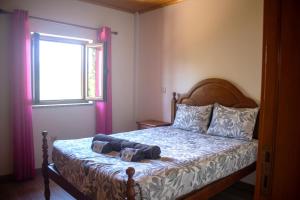 a bedroom with a bed with a dog on it at Casa da Carvalha Mona in Rio Caldo