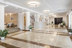 a lobby with potted plants in a building at Hotel Condor in Mamaia