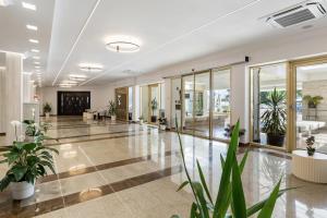 an empty lobby with potted plants in a building at Hotel Condor in Mamaia